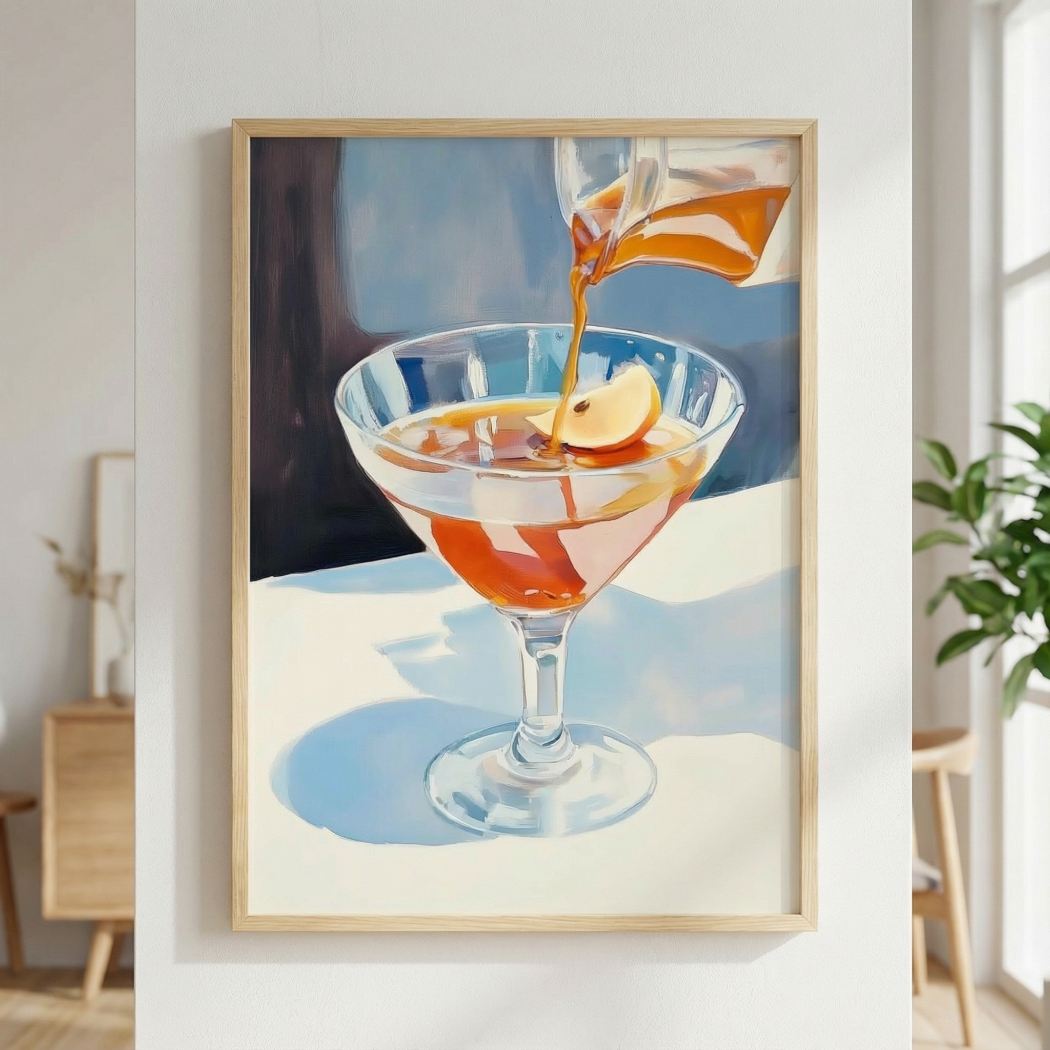 Framed artwork of a cocktail being poured into a glass with a slice of orange.