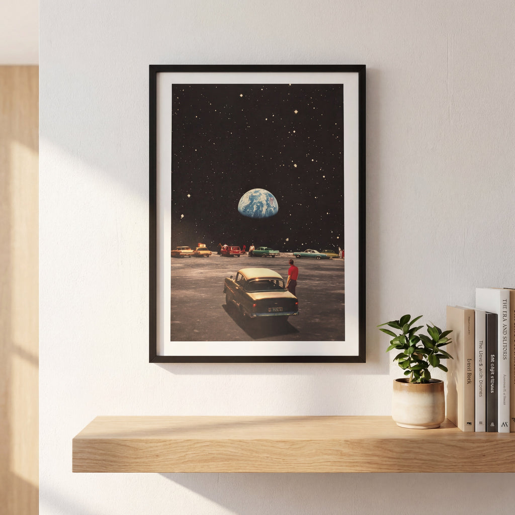 Framed artwork of a car on a runway with Earth in the background, displayed on a wall above a wooden shelf.