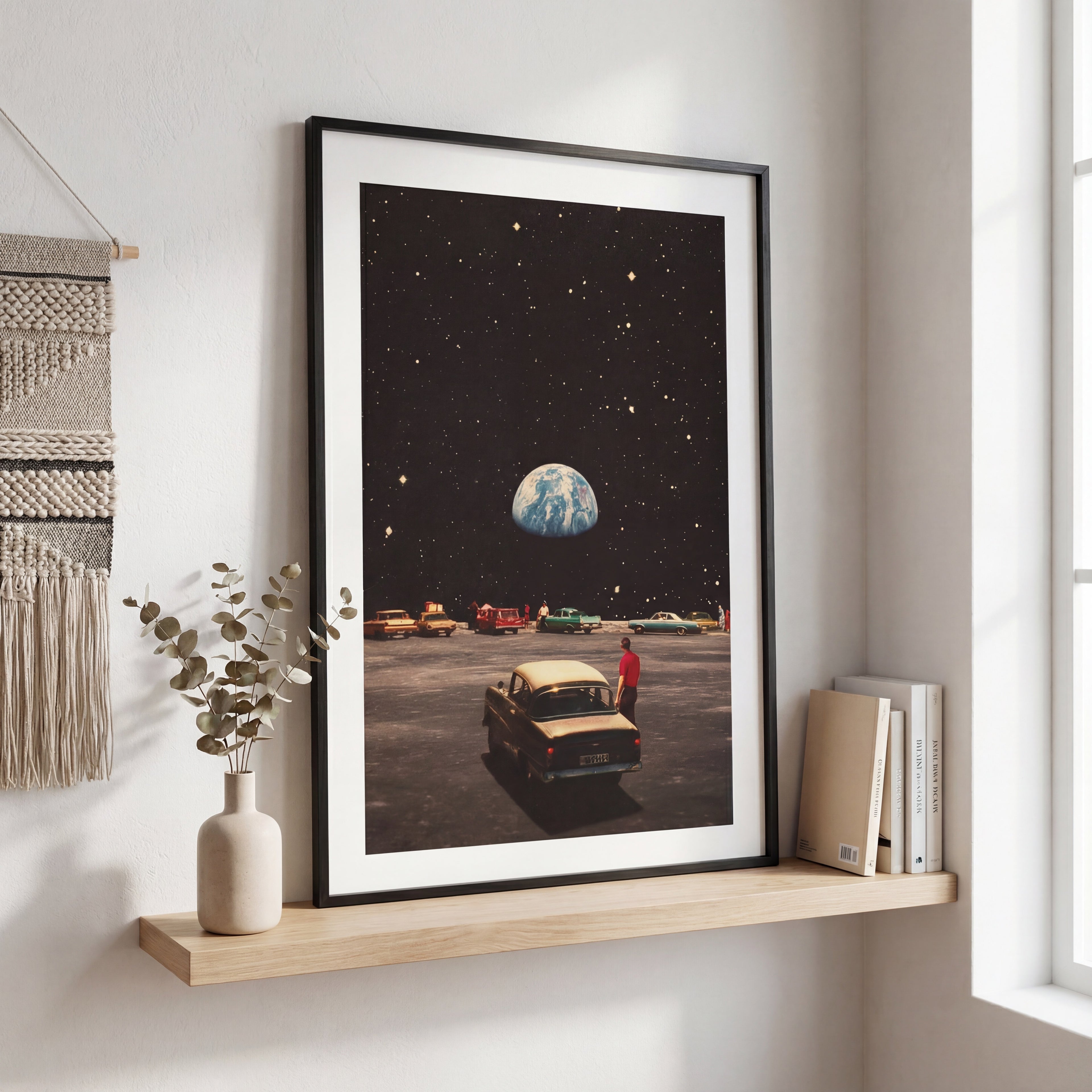 Framed artwork of a car on a moonlit landscape with Earth in the background, displayed on a shelf.
