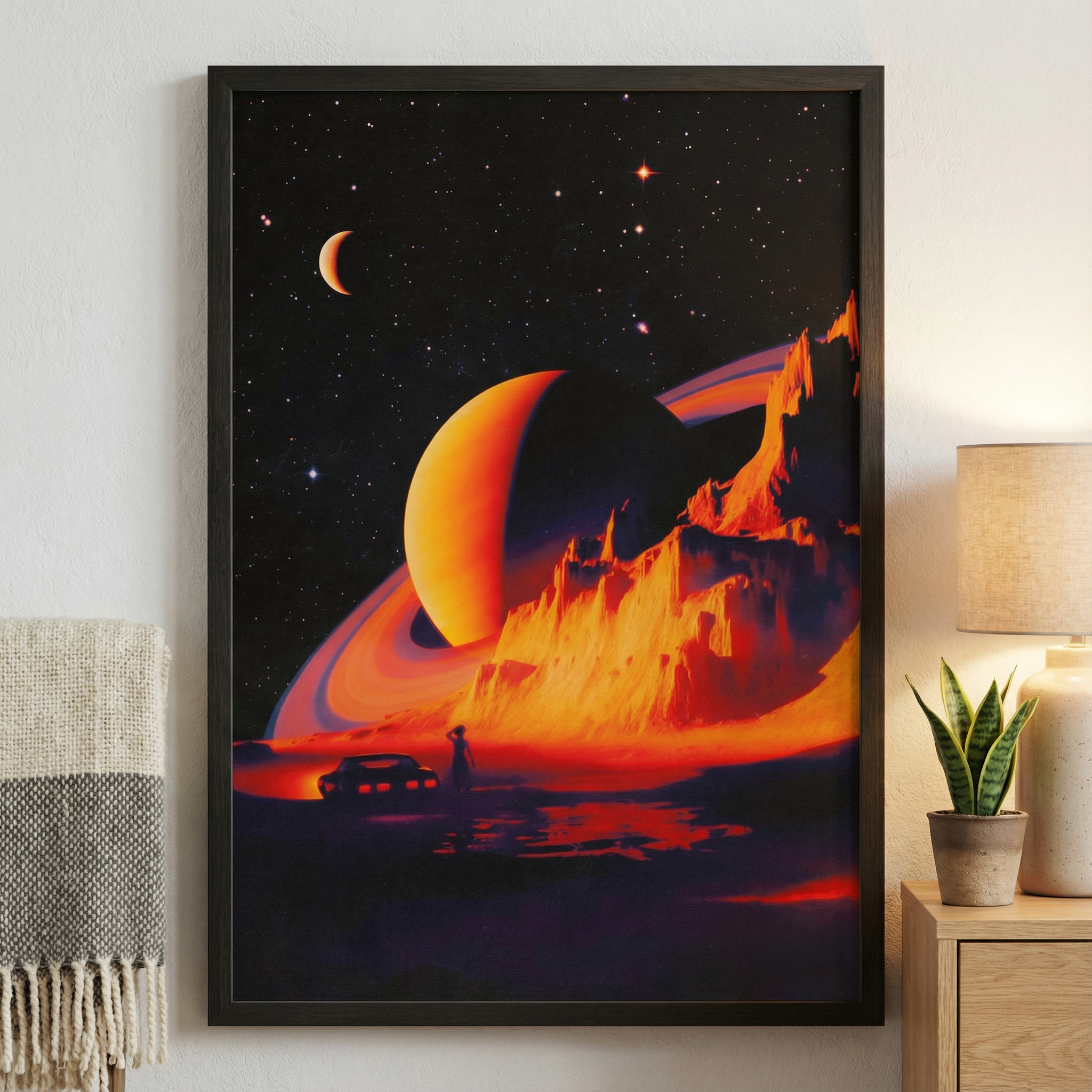 Framed space-themed artwork with a planet and spacecraft on a wall in a room.