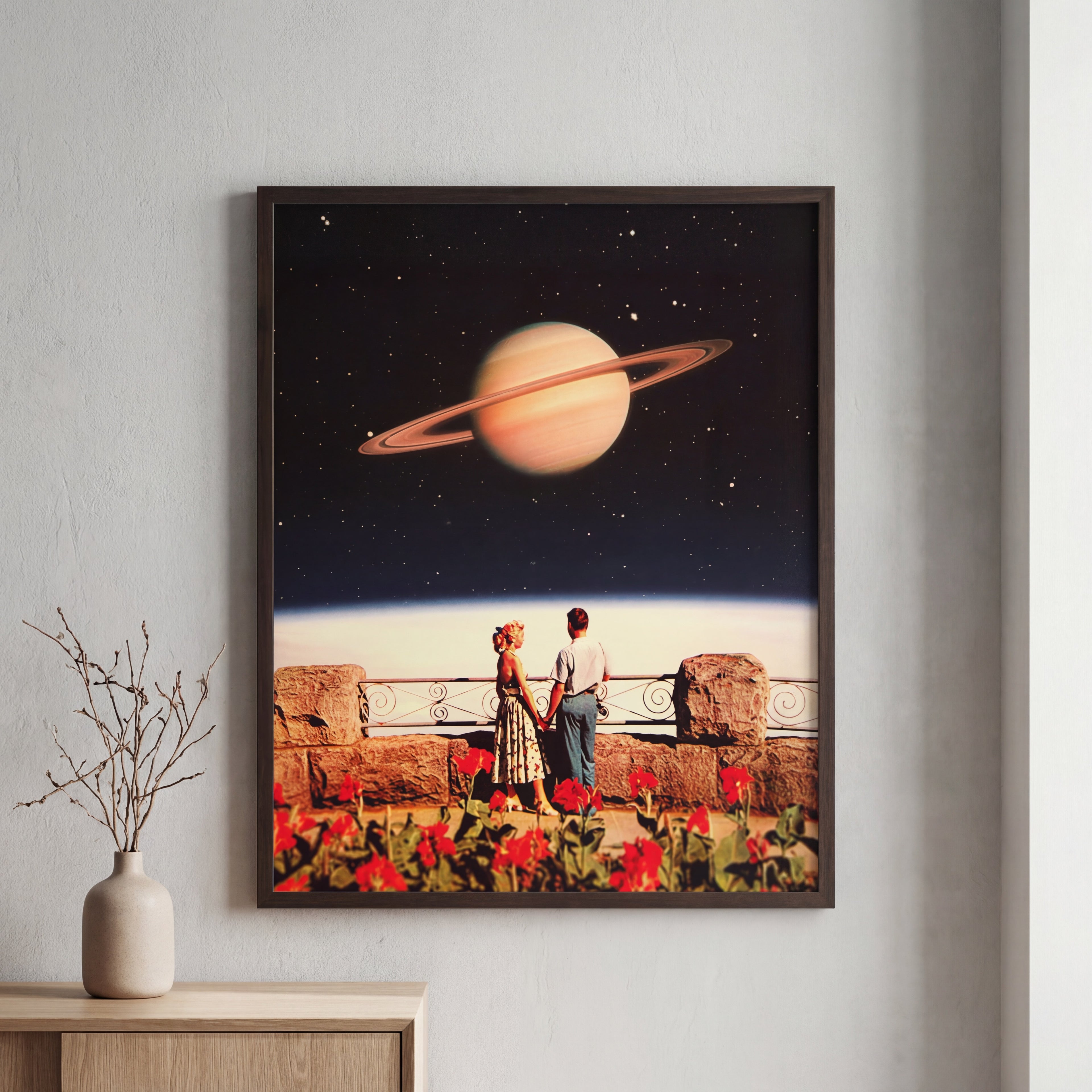 Framed artwork of a couple on a balcony with a planet in the background, displayed on a wall.